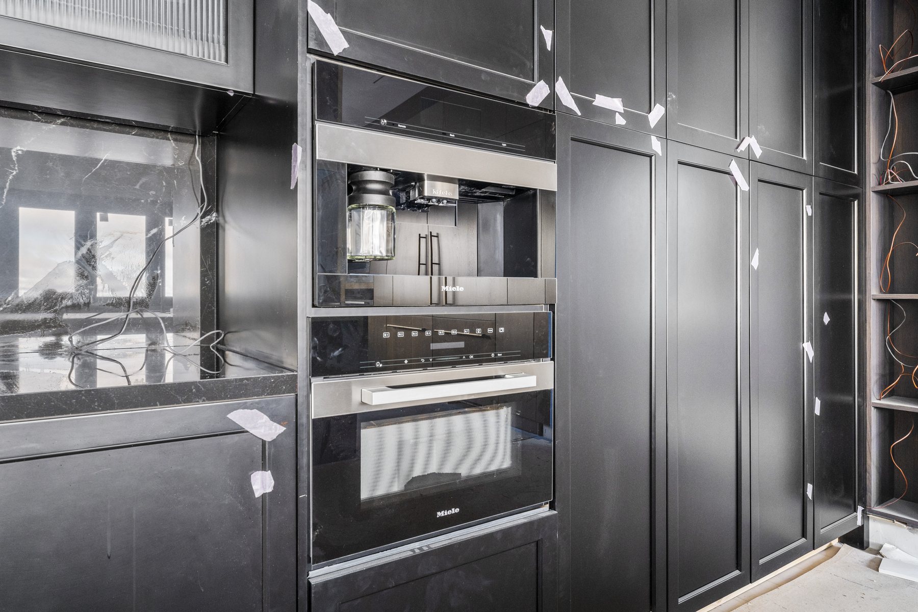 Finished luxury kitchen with dark cabinetry and integrated fixtures