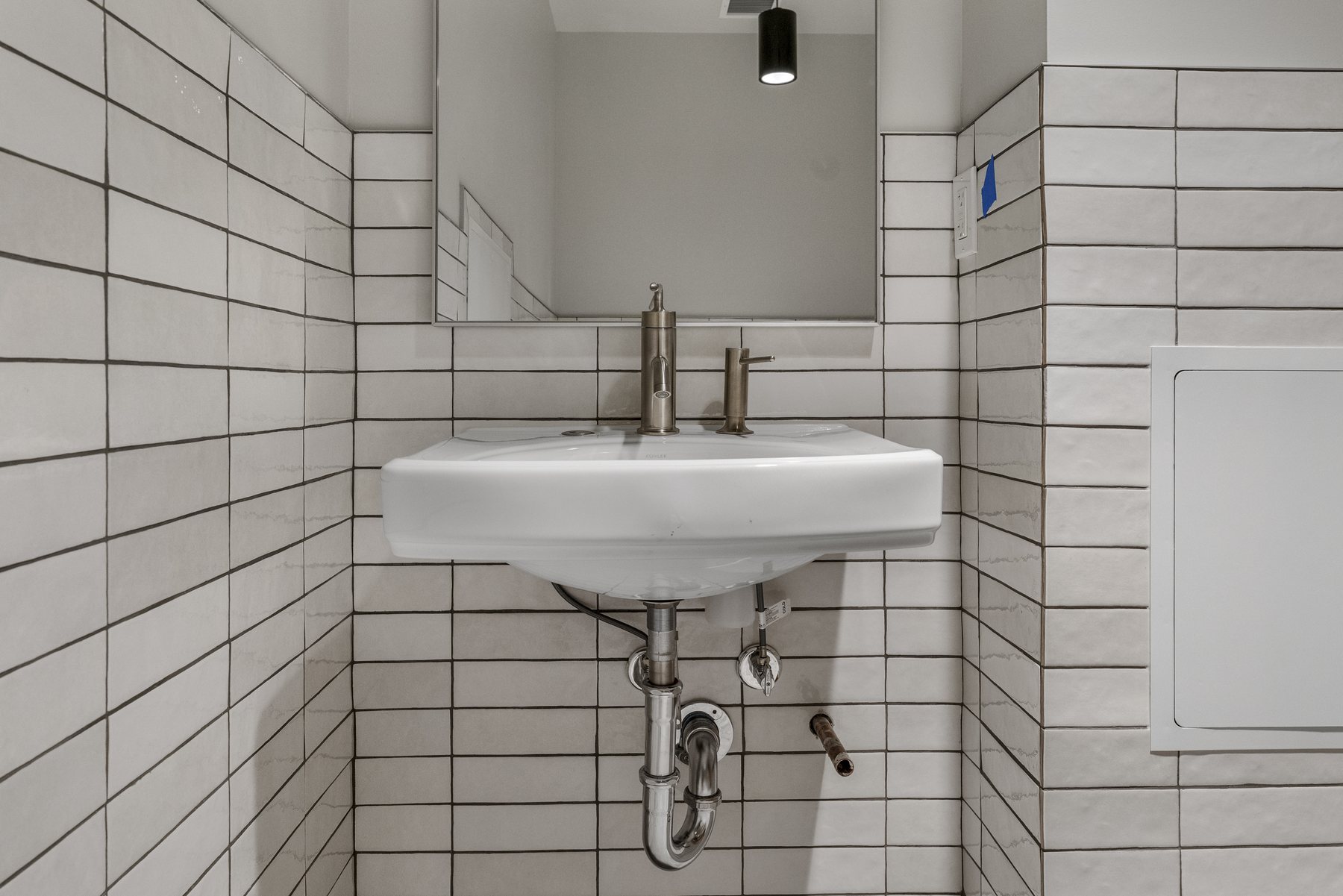 Finished primary bathroom with modern vanity and shower fixtures by Prime Time Plumbing